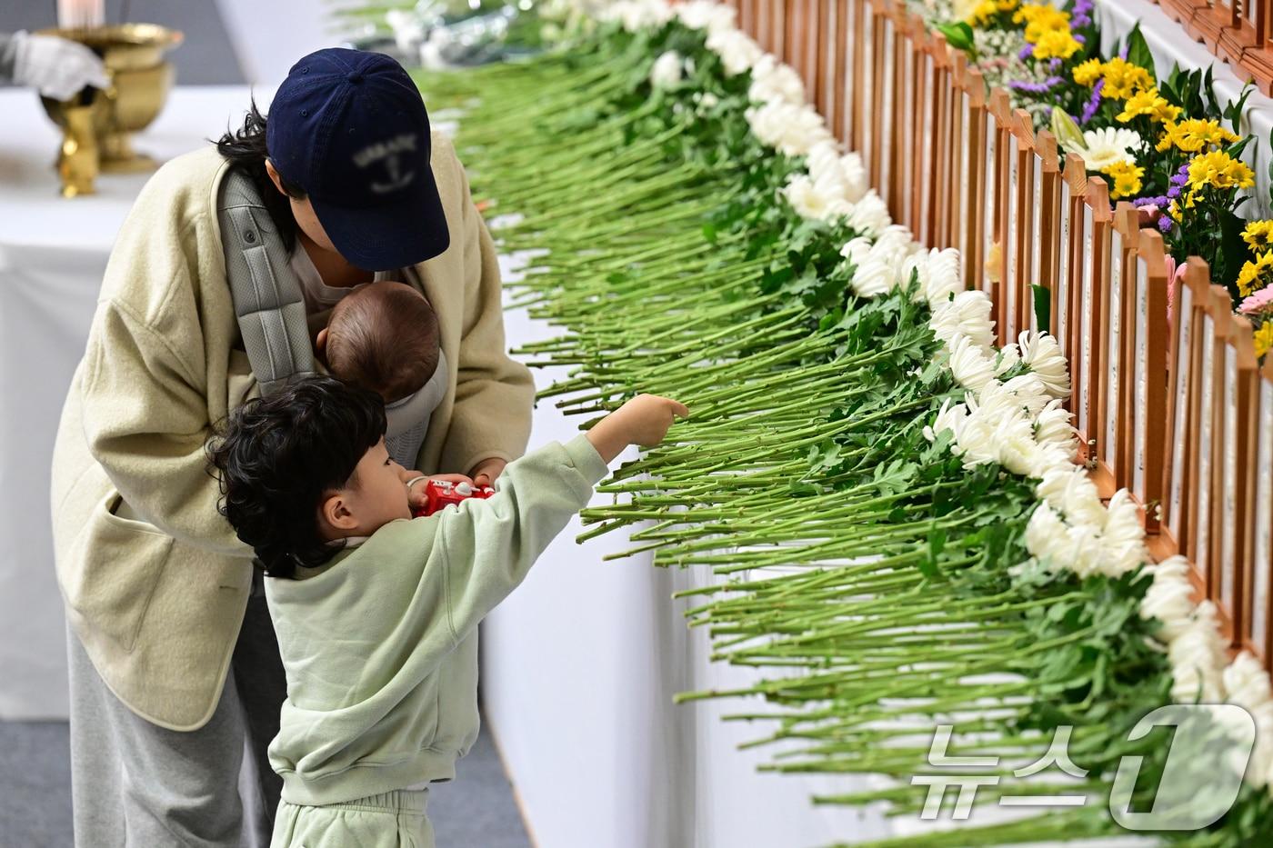 제주항공여객기참사 발생 이틀째인 30일 오후 전남 무안종합스포츠파크에 차려진 합동분향소에서 한 아이가 헌화를 하고 있다. &#40;공동취재&#41; &#40;사진은 기사 내용과 무관함&#41; 2024.12.30/뉴스1 ⓒ News1 김민지 기자