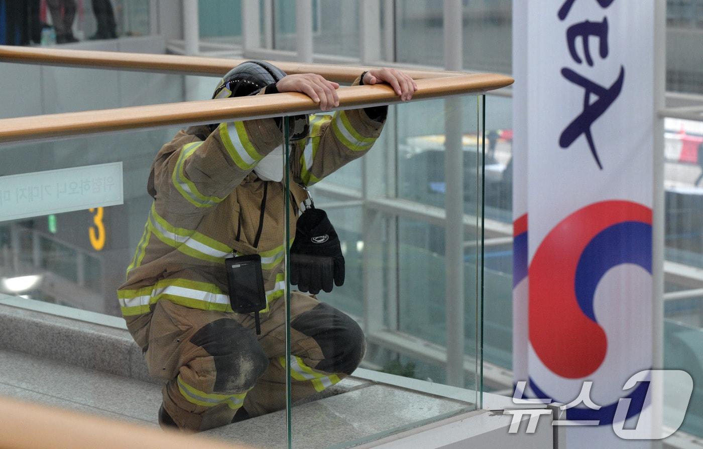 지난달 30일 전남 무안공항에서 제주항공 여객기 사고 현장에 출동한 한 소방대원이 쪼그려 앉아 있다. ⓒ News1 김성진 기자