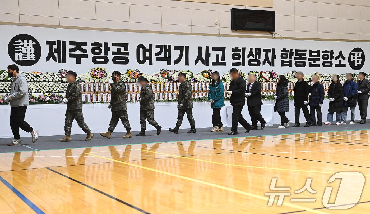 30일 전남 무안군 무안종합스포츠파크에 마련된 제주항공 여객기 사고 희생자 합동분향소에서 조문객들이 헌화하고 있다. &#40;공동취재&#41; 2024.12.30/뉴스1 ⓒ News1 김민지 기자