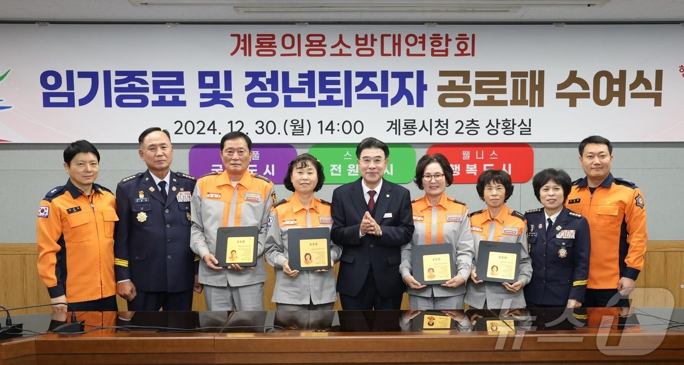 계룡의용소방대연합회 임기종료 및 정년퇴직자 공로패 수여식에서 참석자들이 기념촬영을 하고 있다. 가운데가 이응우 시장. &#40;계룡시 제공&#41; /뉴스1