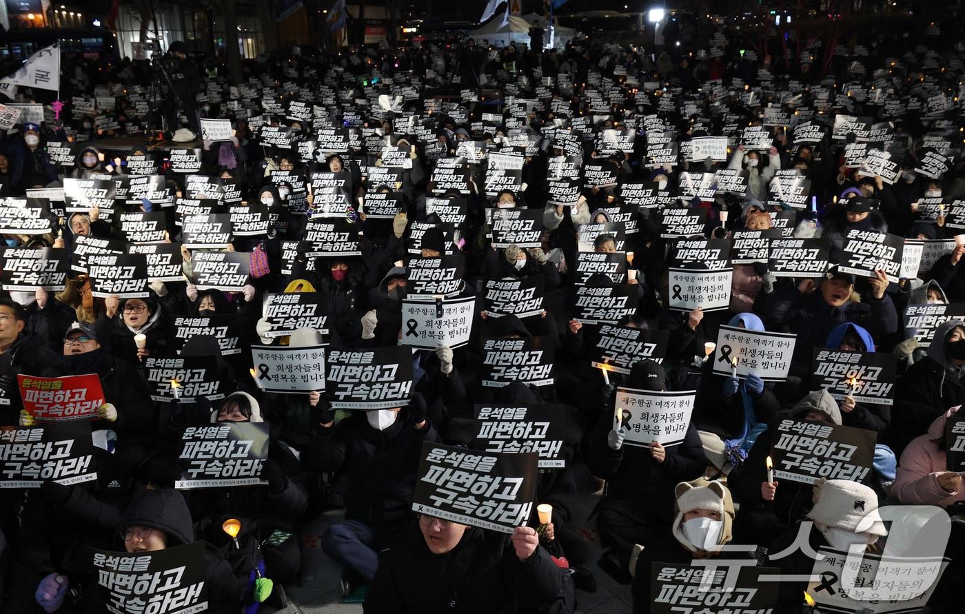 31일 오후 서울 종로구 열린송현녹지광장 앞에서 열린 ‘윤석열 파면 국힘당 해산 촛불문화제’에 참석한 시민들이 구호를 외치고 있다. 2024.12.31/뉴스1 ⓒ News1 박세연 기자