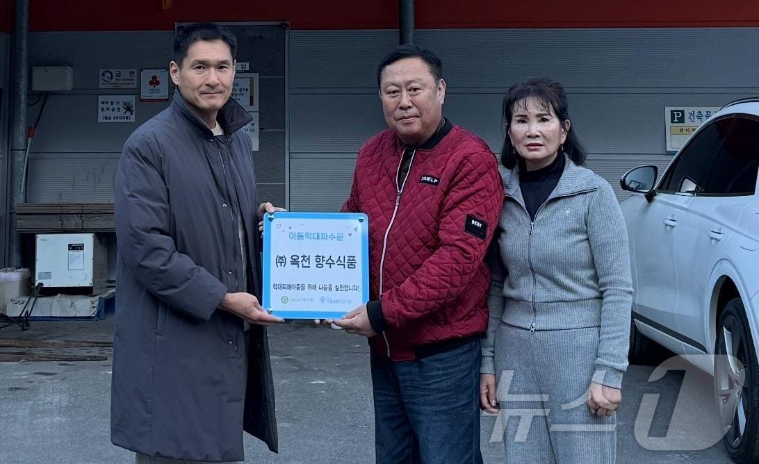 옥천 향수식품 관계자가 아동학대파수꾼 12호점 현판을 받고 있다. &#40;아동보호전문기관 제공&#41; /뉴스1