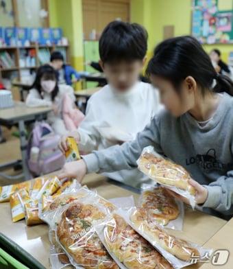 학교비정규직연대회의가 총파업에 돌입한 6일 전북자치도 전주시 홍산초등학교에서 학생들이 대체급식으로 나온 빵과 음료를 가져가고 있다. 2024.12.6/뉴스1 ⓒ News1 유경석 기자