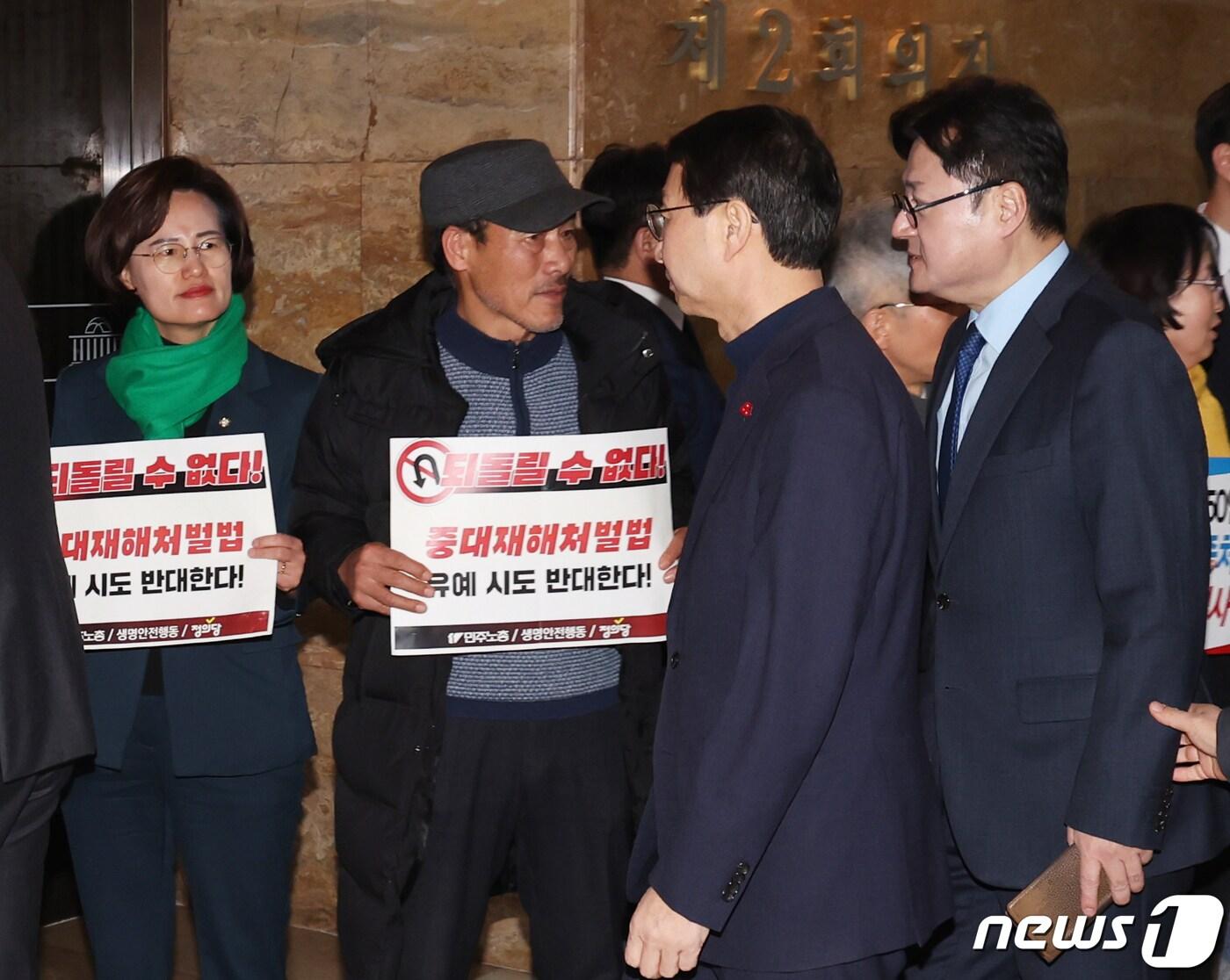 정의당과 한국노총 및 민주노총 회원들이 &#39;중대재해처벌법 개악 협상 중단 촉구&#39; 피켓팅을 하는 가운데 홍익표 더불어민주당 원내대표가 1일 서울 여의도 국회에서 비공개로 열린 더불어민주당 의원총회 회의장에 들어가고 있다. 2024.2.1/뉴스1 ⓒ News1 송원영 기자