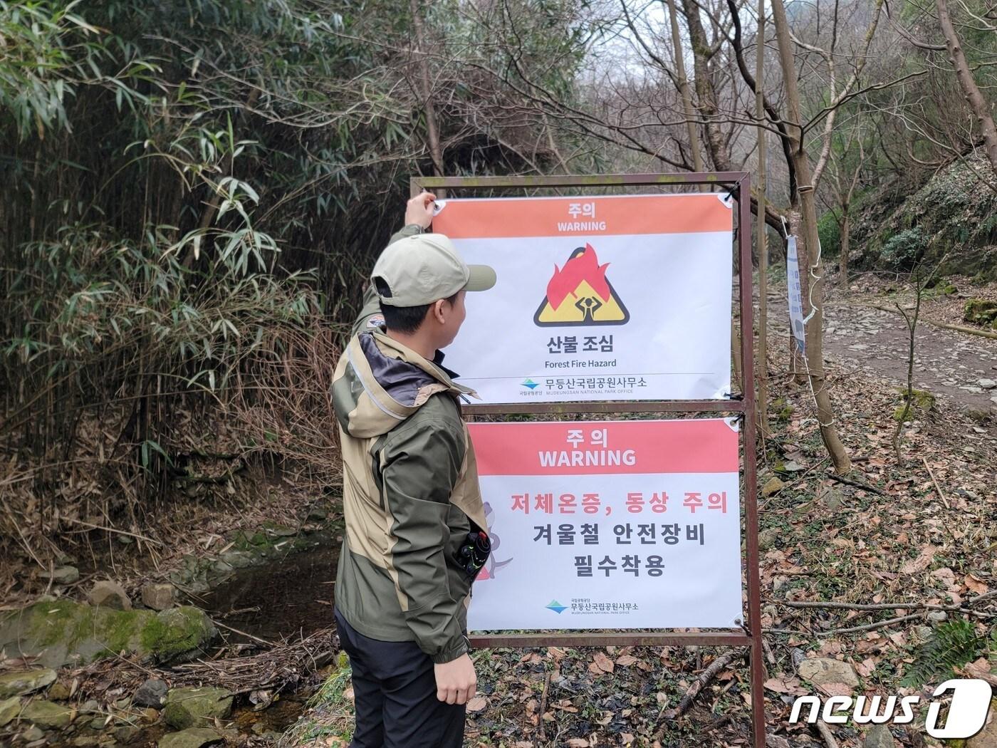 13일 국립공원공단 무등산국립공원사무소 관계자가 탐방로 인근에 산불 조심 깃발을 게첩하고 있다. &#40;공단 제공&#41; 2024.2.13/뉴스1