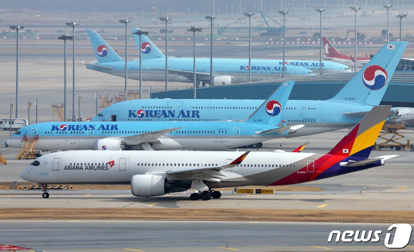  인천국제공항 활주로에서 아시아나항공 항공기가 대한항공 항공기 앞을 지나고 있다. 2024.2.13/뉴스1 ⓒ News1 박정호 기자