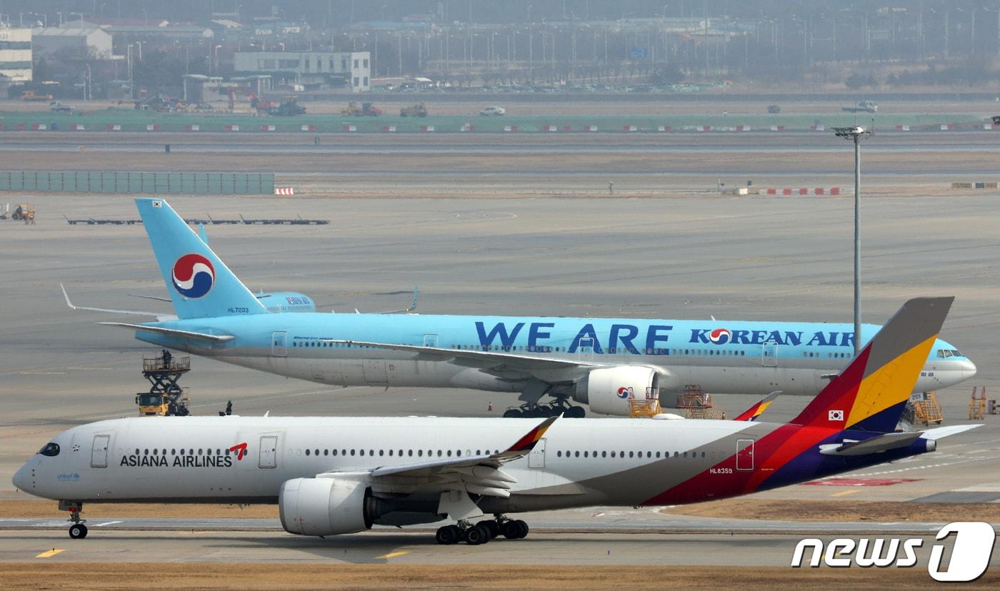 13일 인천국제공항 활주로에서 아시아나항공 항공기가 대한항공 항공기 앞을 지나고 있다. 2024.2.13/뉴스1 ⓒ News1 박정호 기자