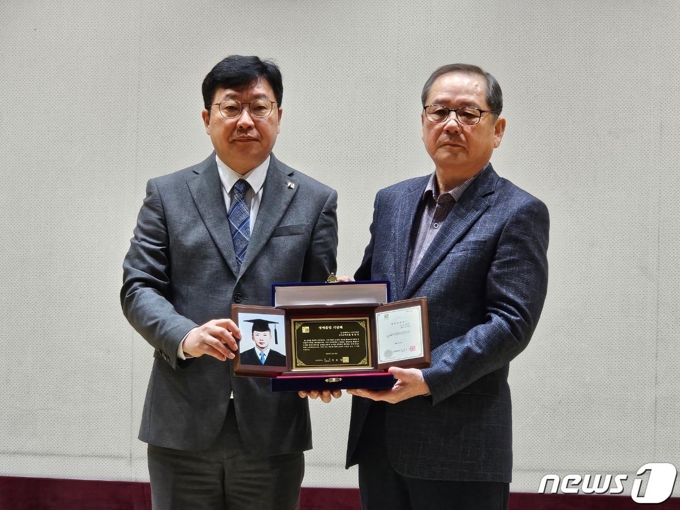 김춘성 조선대학교 총장&#40;왼쪽&#41;이 16일 고 정선엽 병장 명예졸업식에서 정 병장의 동생 규상씨&#40;오른쪽&#41;에 명예졸업장과 기념패를 전달하고 있다. 정 병장은 1979년 12월13일 12·12군사반란군과 맞서다 총격을 받고 전사했다. 2024.2.16./뉴스1 ⓒ News1 서충섭 기자