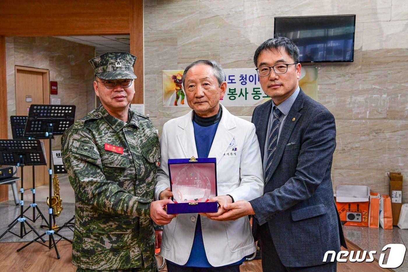 권태균 해병대 제6여단장&#40;사진 왼쪽&#41;과 임상훈 인천 옹진군 백령면장&#40;사진 오른쪽&#41;이 이두익 백령병원장에게 감사 공로패를 전달하고 있다.&#40;해병대 제6여단 제공&#41;/뉴스1 