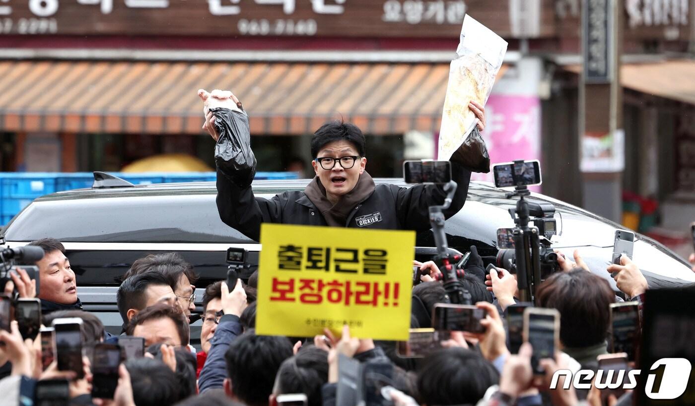 한동훈 국민의힘 비상대책위원장이 설 명절 연휴를 나흘 앞둔 5일 서울 동대문구 청량리 청과물시장·경동시장을 방문해 구매한 상품을 들어보이며 시민들과 인사를 나누고 있다. &#40;공동취재&#41; 2024.2.5/뉴스1 ⓒ News1 임세영 기자