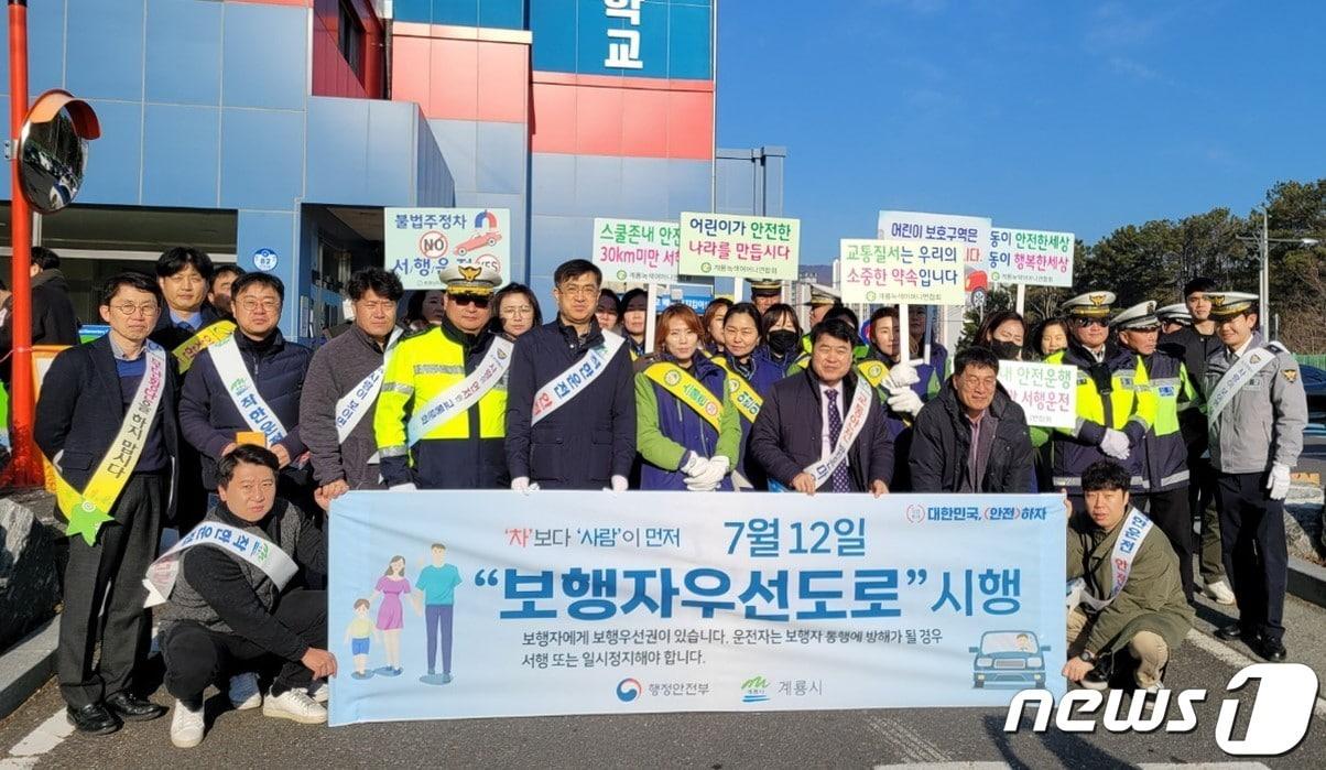 계룡 엄사면 신도초에서 진행된 ‘어린이 교통안전 합동 캠페인’에서 관계자들이 단체사진을 찍고 있다. &#40;계룡시 제공&#41; /뉴스1 