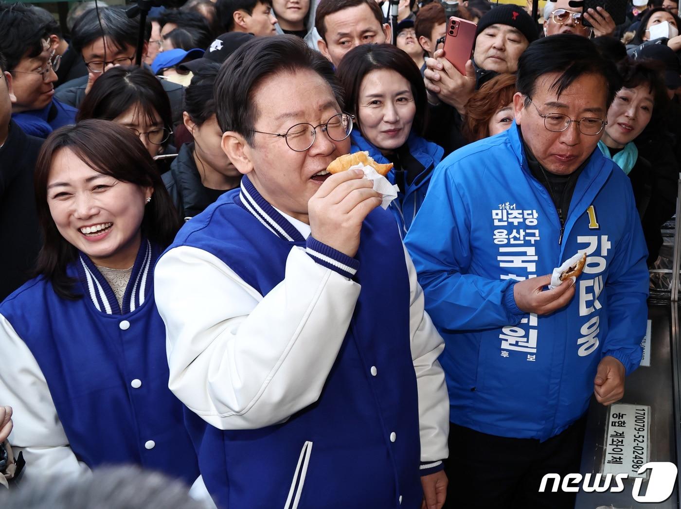 이재명 더불어민주당 대표가 13일 오후 서울 용산구 용문시장을 찾아 강태웅 후보, 백승아 더불어민주연합 공동대표와 함께 찹쌀 도너츠를 맛보고 있다. 2024.3.13/뉴스1 ⓒ News1 구윤성 기자