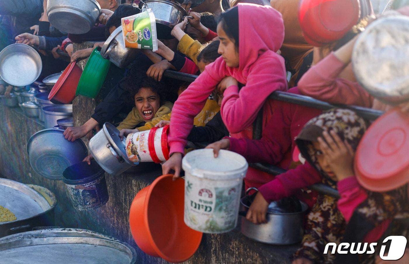 13일&#40;현지시간&#41; 가자지구 남부 라파에서 팔레스타인 주민들이 식량을 받기 위해 기다리는 모습. 이슬람 금식 성월인 라마단 기간에도 양측 간 분쟁은 계속되고 있다. 24.03.13 ⓒ 로이터=뉴스1 ⓒ News1 김예슬 기자
