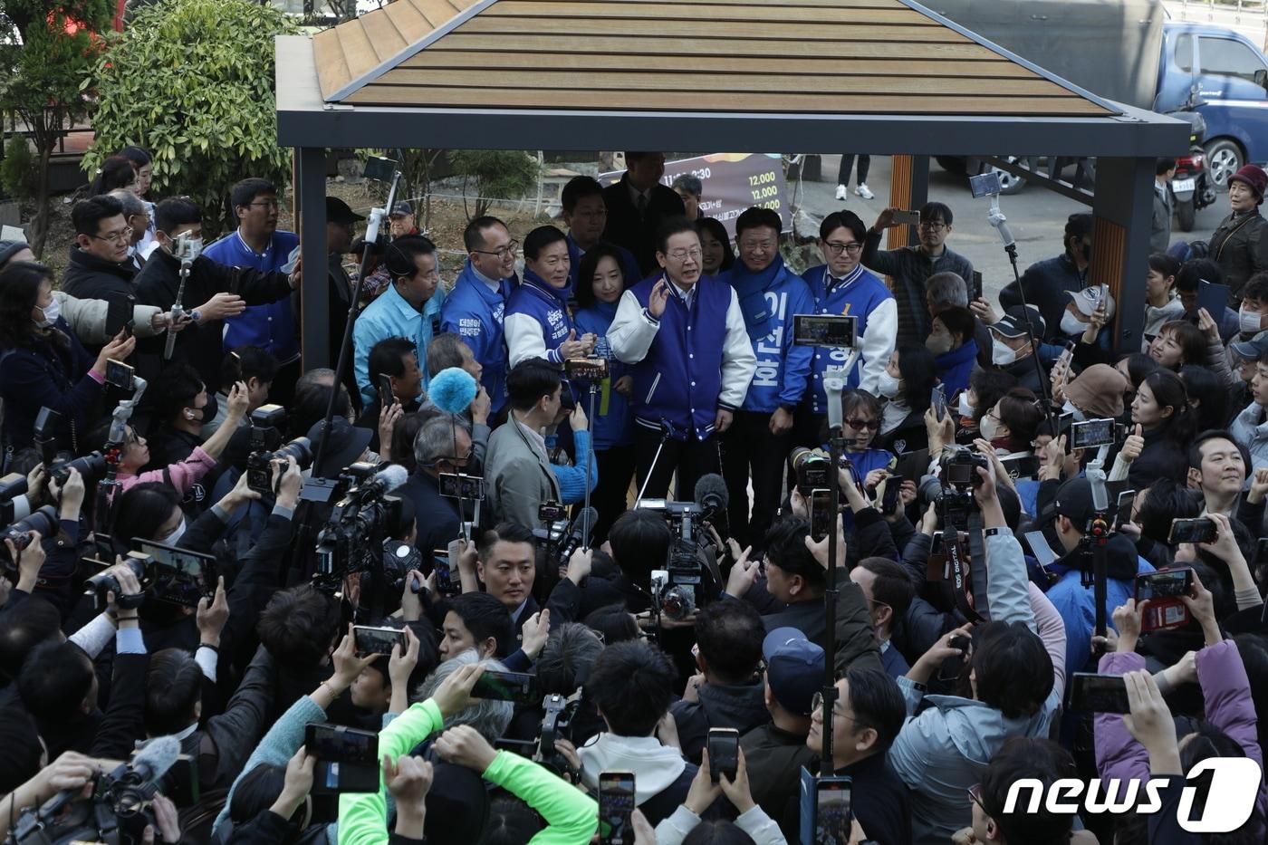 이재명 더불어민주당 대표가 3월15일 울산 남구 수암시장을 방문해 시민들에게 인사말을 하고 있다. 진보당 윤종오 후보가 이재명 대표 왼쪽에서 4번째 하늘색 유니폼을 입고 있다. 2024.3.15/뉴스1 ⓒ News1 김지혜 기자