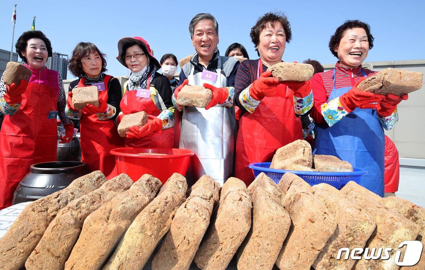 18일 오후 대구 달서구노인종합복지관 옥상에서 열린 &#39;달서구 어르신 장&#40;醬&#41; 담그기&#39; 행사에 참여한 어르신과 결혼이주여성 등 주민들이 장독대에 모여 장 담그기에 사용할 메주를 들어 보이고 있다. 2024.3.18/뉴스1 ⓒ News1 공정식 기자