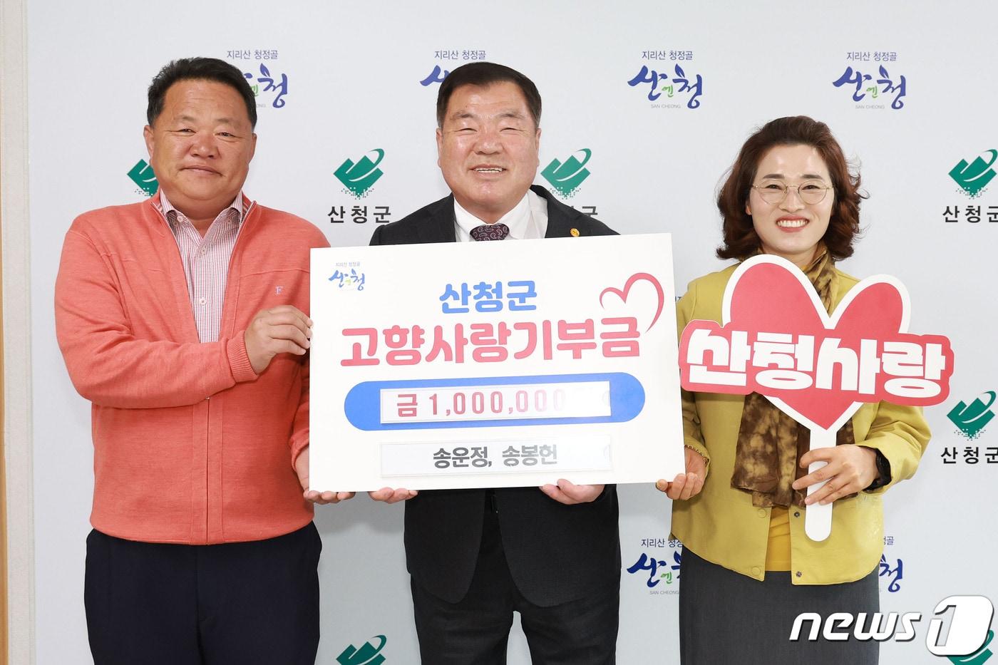 산청군 고향사랑기부제 500호 기부자 송운정·봉헌 남매의 아버지 송이석씨&#40;왼쪽&#41;와 어머니 이지현씨&#40;오른쪽&#41;가 19일 이승화 산청군수에서 기부금을 전달하고 있다. 2024.3.19