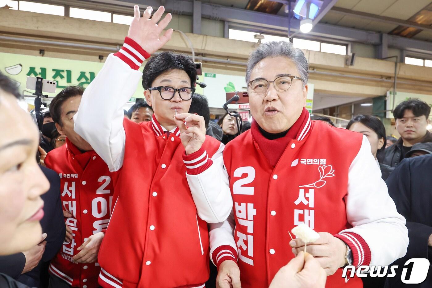 한동훈 국민의힘 총괄선대위원장이 19일 오후 서울 서대문구 인왕시장에 이용호 서대문갑·박진 서대문을 후보와 함께 방문해 상인들에게 받은 떡을 맛보고 있다. 2024.3.19/뉴스1 ⓒ News1 민경석 기자