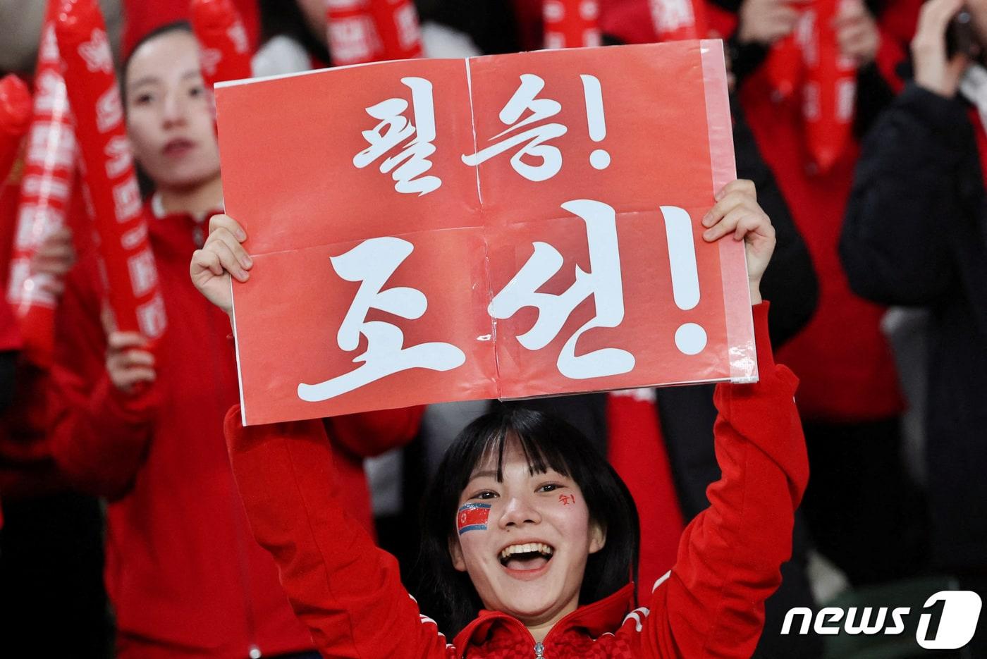 북한 축구대표팀을 응원하는 팬 ⓒ 로이터=뉴스1