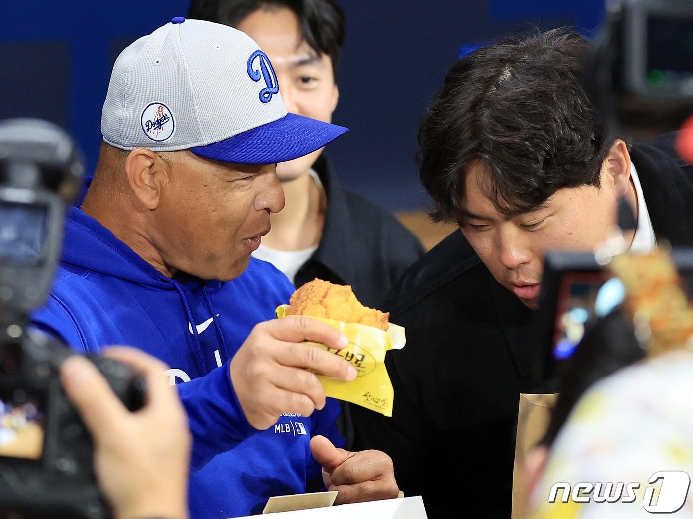 20일 서울 구로구 고척스카이돔에서 열리는 2024 미국 메이저리그&#40;MLB&#41; 월드투어 서울시리즈 개막전 샌디에이고 파드리스와 로스엔젤레스&#40;LA&#41; 다저스의 경기를 앞두고 데이브 로버츠 다저스 감독이 올시즌 KBO리그 개막을 앞두고 한화 이글스로 전격 컴백한 류현진이 선물한 빵을 맛있게 먹고 있다. 2024.3.20/뉴스1 ⓒ News1 김진환 기자