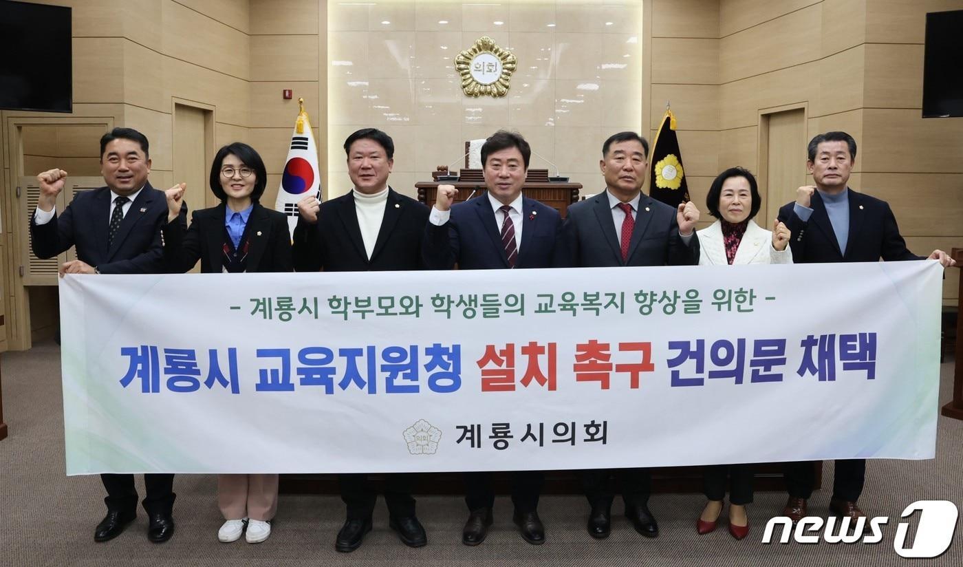 김범규 계룡시의회 의장&#40;오른쪽 세번째&#41;과 의원들이 ‘제171회 임시회’에서 계룡교육지원청 설치 촉구 건의문을 채택한 뒤 사진을 찍고 있다. &#40;계룡시의회 제공&#41; /뉴스1