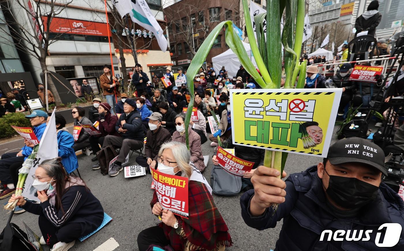 촛불행동 회원들이 30일 서울 중구 세종대로에서 열린 정부 규탄 집회에서 대파와 손피켓을 들고 구호를 외치고 있다. 2024.3.30/뉴스1 ⓒ News1 김도우 기자