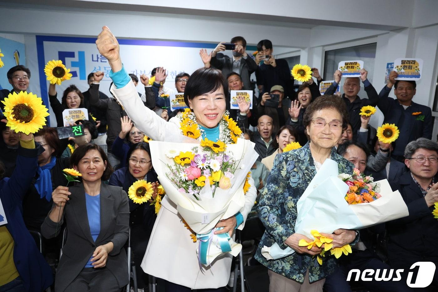 전현희 더불어민주당 서울 중·성동갑 후보가 10일 오후 서울 성동구 왕십리로에 마련된 자신의 선거사무실에서 당선이 유력해지자 꽃다발을 전달받고 있다. 2024.4.10/뉴스1 ⓒ News1 신웅수 기자