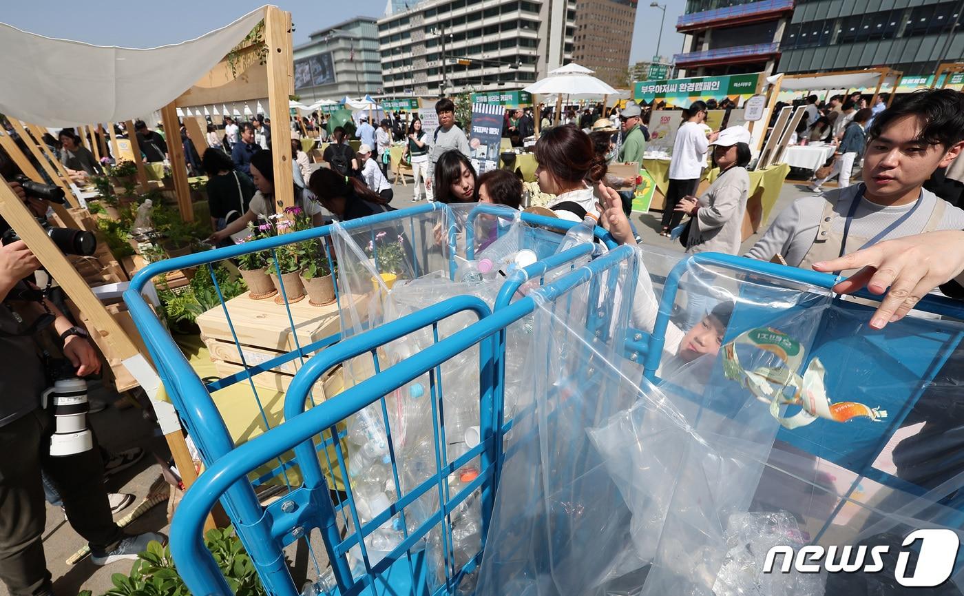 서울 종로구 광화문광장에서 열린 &#39;2024 지구의 날&#39; 기념행사에서 시민들이 쓰레기 분리수거를 한 후 화분을 받고 있다. 2024.4.13/뉴스1 ⓒ News1 김성진 기자