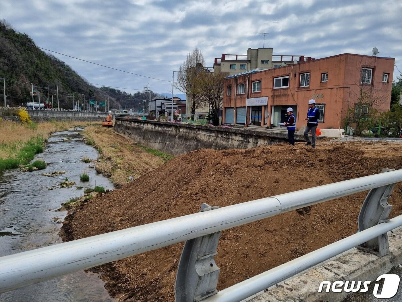 수자원공사 관계자들이 최근 충북 단양군 평동 2리 부근에서 하천변에 방치된 흙더미를 점검하고 있다. &#40;한국수자원공사 제공&#41;/뉴스1