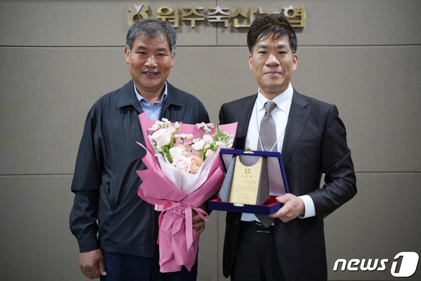 신동훈 강원 원주축산업협동조합장이 15일 오전 조합 본점에서 지역 축산업 활성화를 도운 원주시청 공무원노동조합의 문성호 사무국장&#40;오른쪽&#41;에게 감사패를 전달했다. &#40;원주시청 공무원노동조합 제공&#41; 2024.4.15/뉴스1