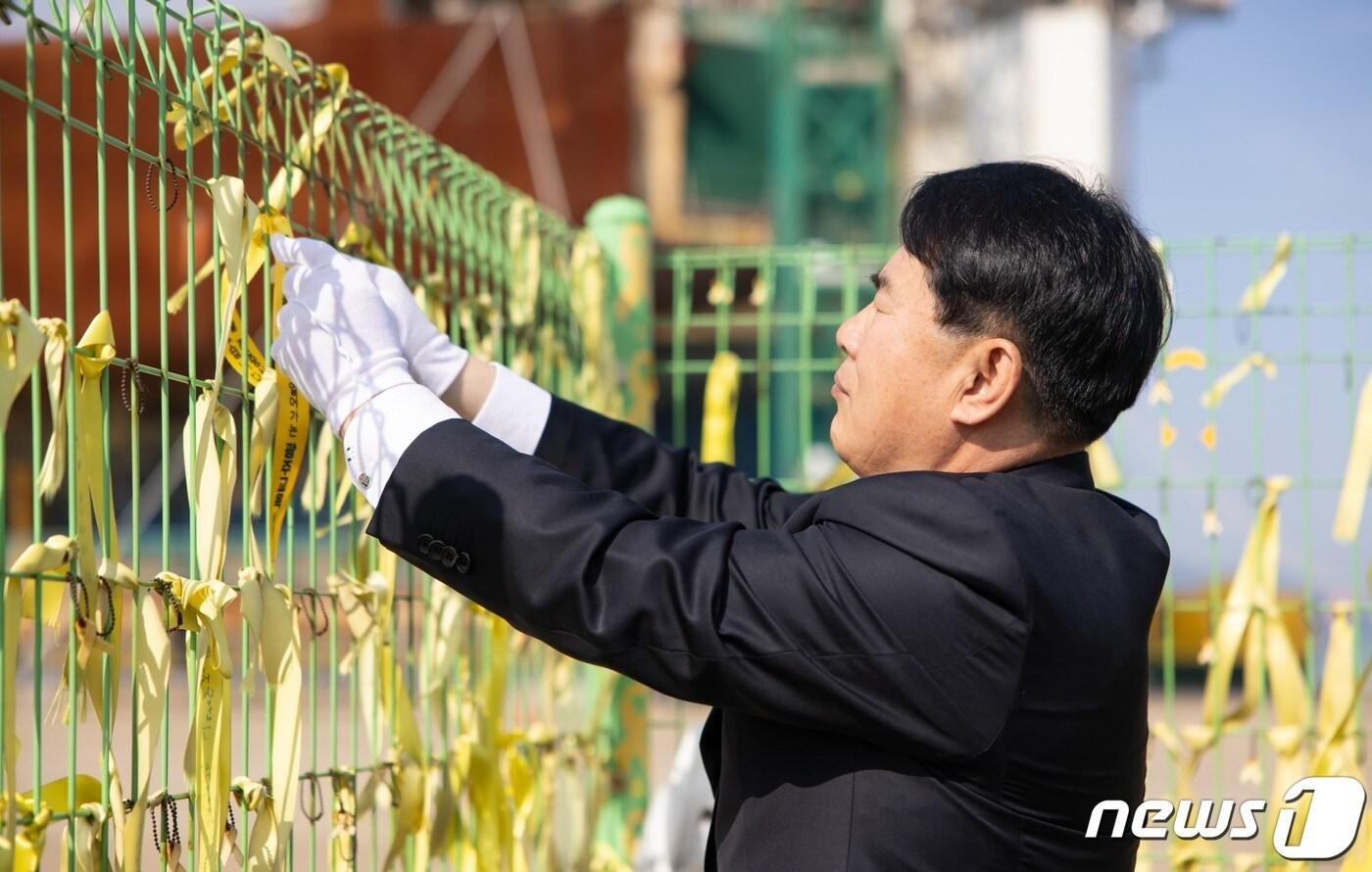 이정선 광주시교육감이 세월호 10주기를 앞둔 12일 목포신항에서 세월호 희생자들을 추모하는 노란 리본을 매달고 있다.&#40;광주시교육청 제공&#41;2024.4.12./뉴스1