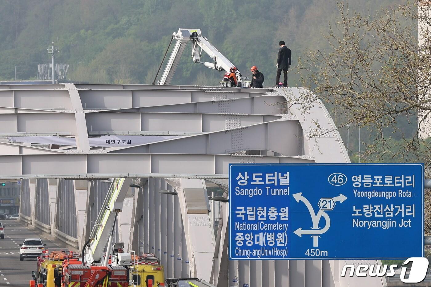 17일 오전 서울 한강대교 노량진 방면에서 신원을 알 수 없는 남성이 교량 위에 올라가 소동을 벌이고 있다. 2024.4.17/뉴스1 ⓒ News1 김도우 기자