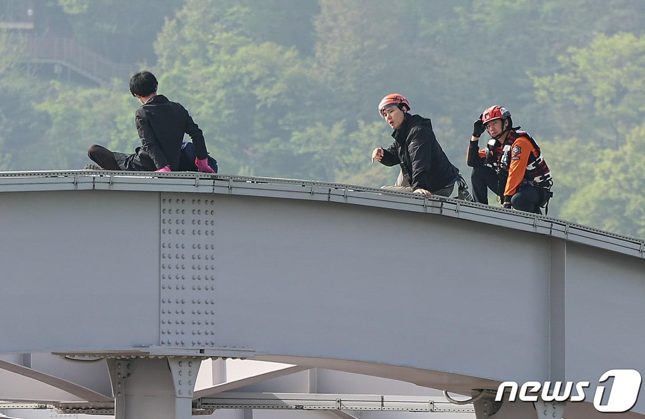 17일 오전 서울 한강대교 노량진 방면에서 교량 위에 올라가 소동을 벌이고 있는 신원을 알 수 없는 남성을 현장에 출동한 소방대원들이 설득하고 있다. 2024.4.17/뉴스1 ⓒ News1 김도우 기자