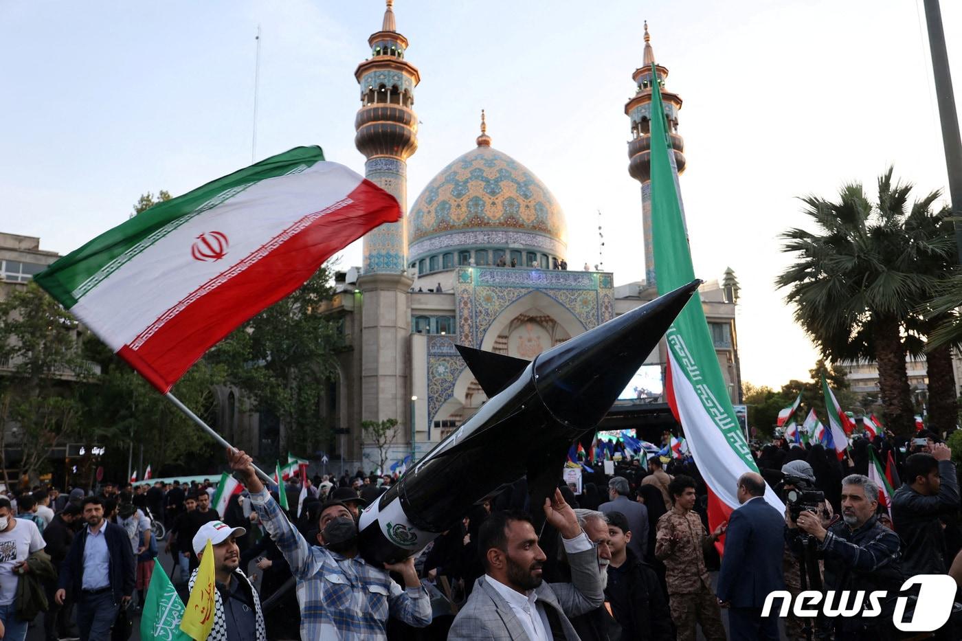 이스라엘이 이란의 공습을 받은 다음 날인 15일&#40;현지시간&#41; 이란 수도 테헤란에서 이란인들이 미사일 모형을 들고 자축하고 있다. 2024.04.15 ⓒ 로이터=뉴스1 ⓒ News1 정지윤 기자