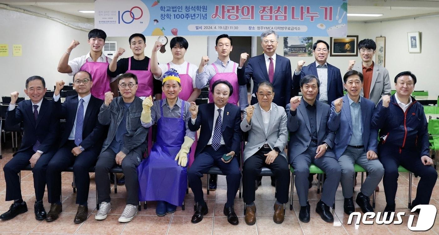 학교법인 청석학원 창학 100주년 기념사업회 오영식 회장&#40;앞줄 왼쪽 다섯번째&#41;과 회원들이 19일 청주 중앙공원 YMCA 무료급식소에서 사랑의 점심 나누기 봉사활동을 펼친 뒤 기념촬영을 하고 있다.&#40;청주대 제공&#41;/뉴스1