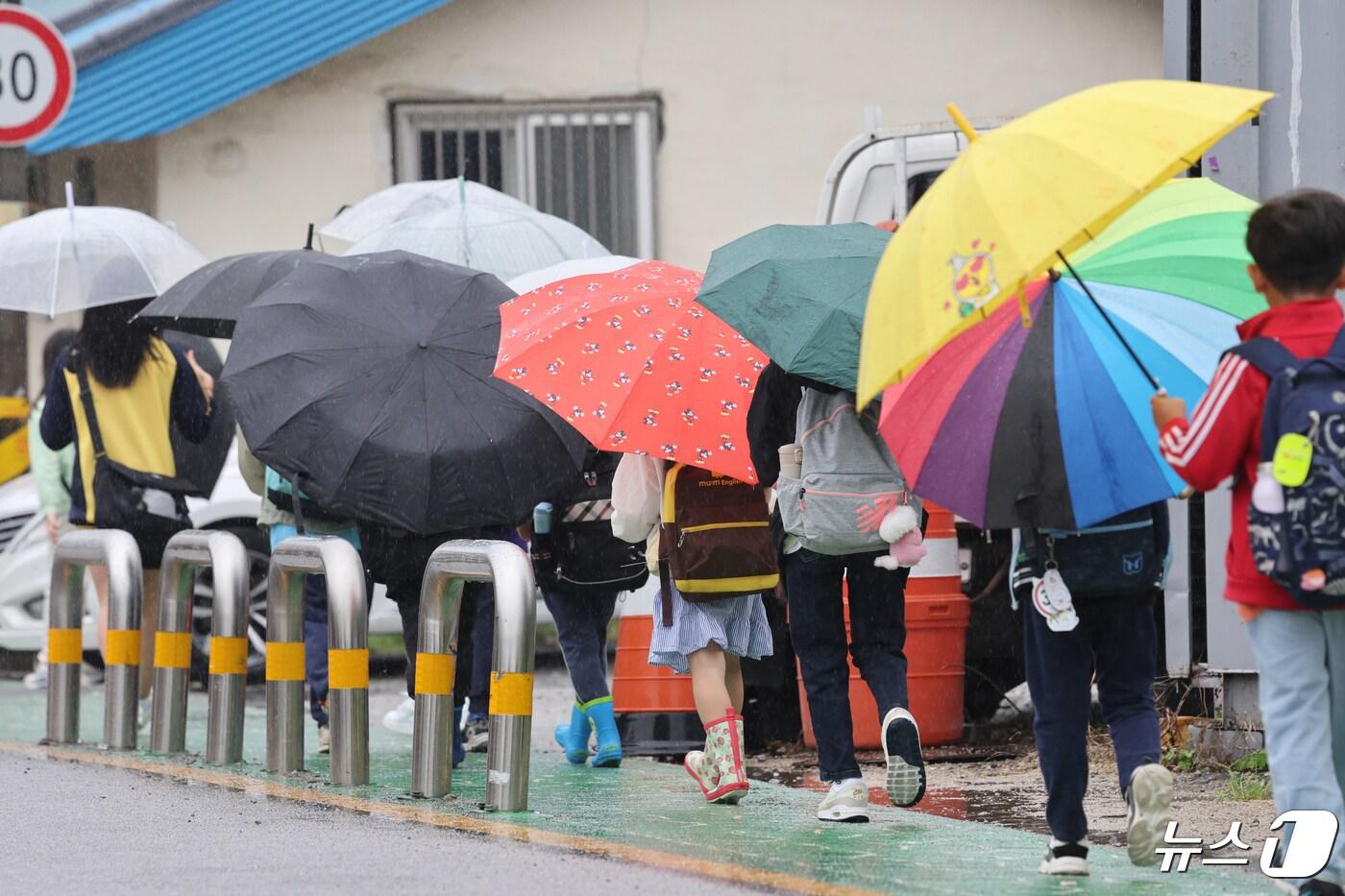 봄비가 내리는 29일 광주 광산구 수완동 한 아파트 입구에서 초등학생들이 우산을 쓰고 등교하고 있다. 2024.4.29/뉴스1 ⓒ News1 김태성 기자