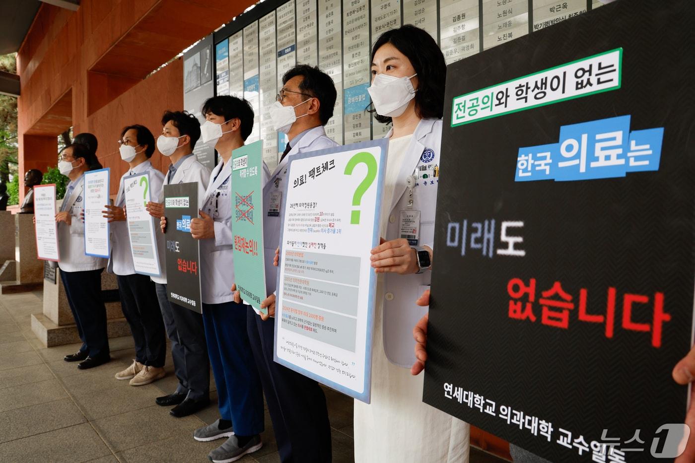 안석균 연세대학교 의과대학 비상대책위원장&#40;왼쪽 첫번째&#41;을 비롯한 교수들이 외래 진료 휴진에 들어간 지난달 30일 서울 서대문구 세브란스병원 본관 앞에서 의대정원 확대 등 정부 의료개혁 원점 재논의를 촉구하며 손팻말을 들고 있다. 2024.4.30/뉴스1 ⓒ News1 안은나 기자