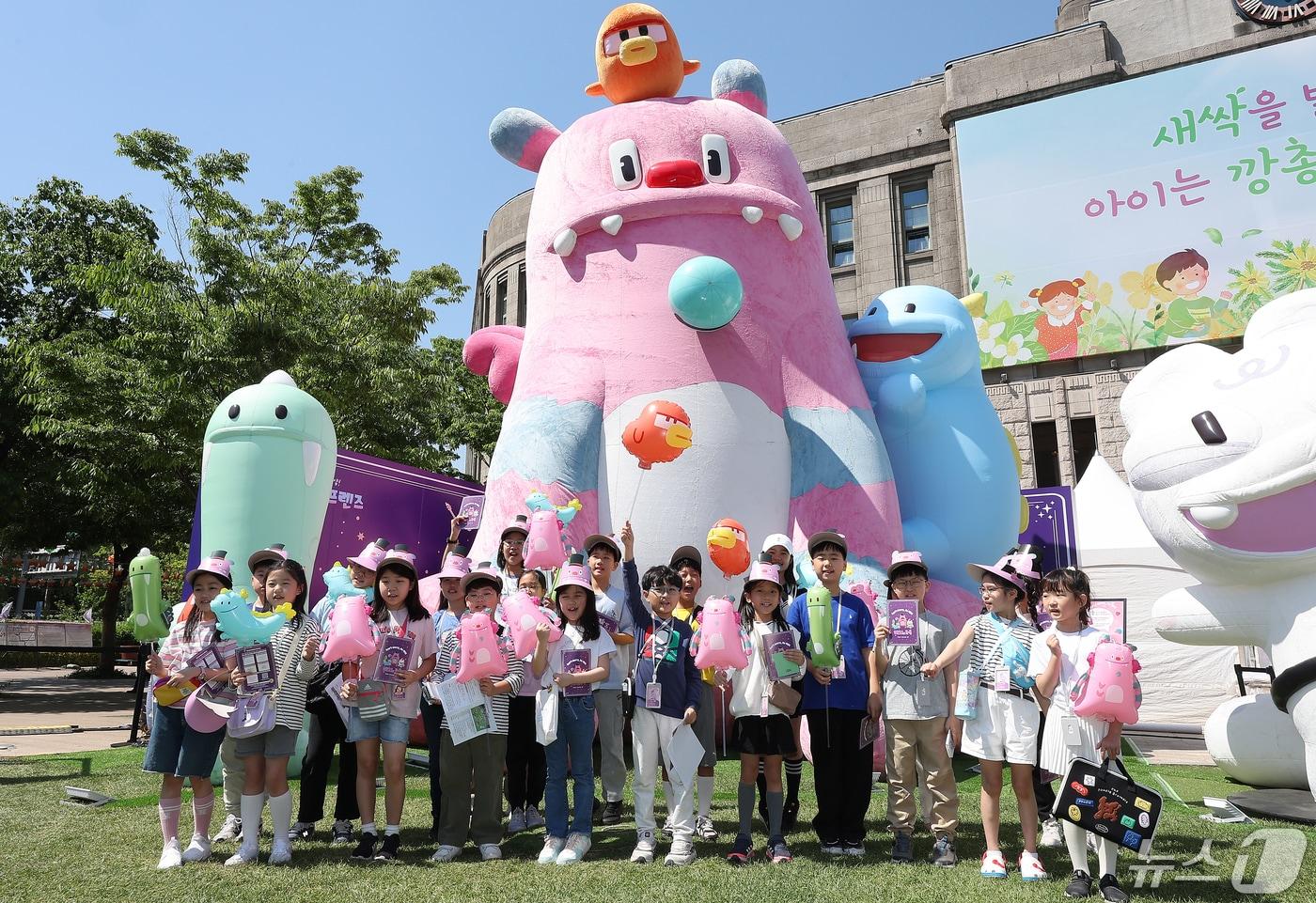 서울시 어린이 기자단이 지난 달 서울 중구 서울광장 잔디광장에 마련된 ‘해치의 마법마을’ 팝업스토어에서 대형 해치와 소울프랜즈 캐릭터 앞에서 기념 촬영을 하고 있다.  ⓒ News1 김진환 기자