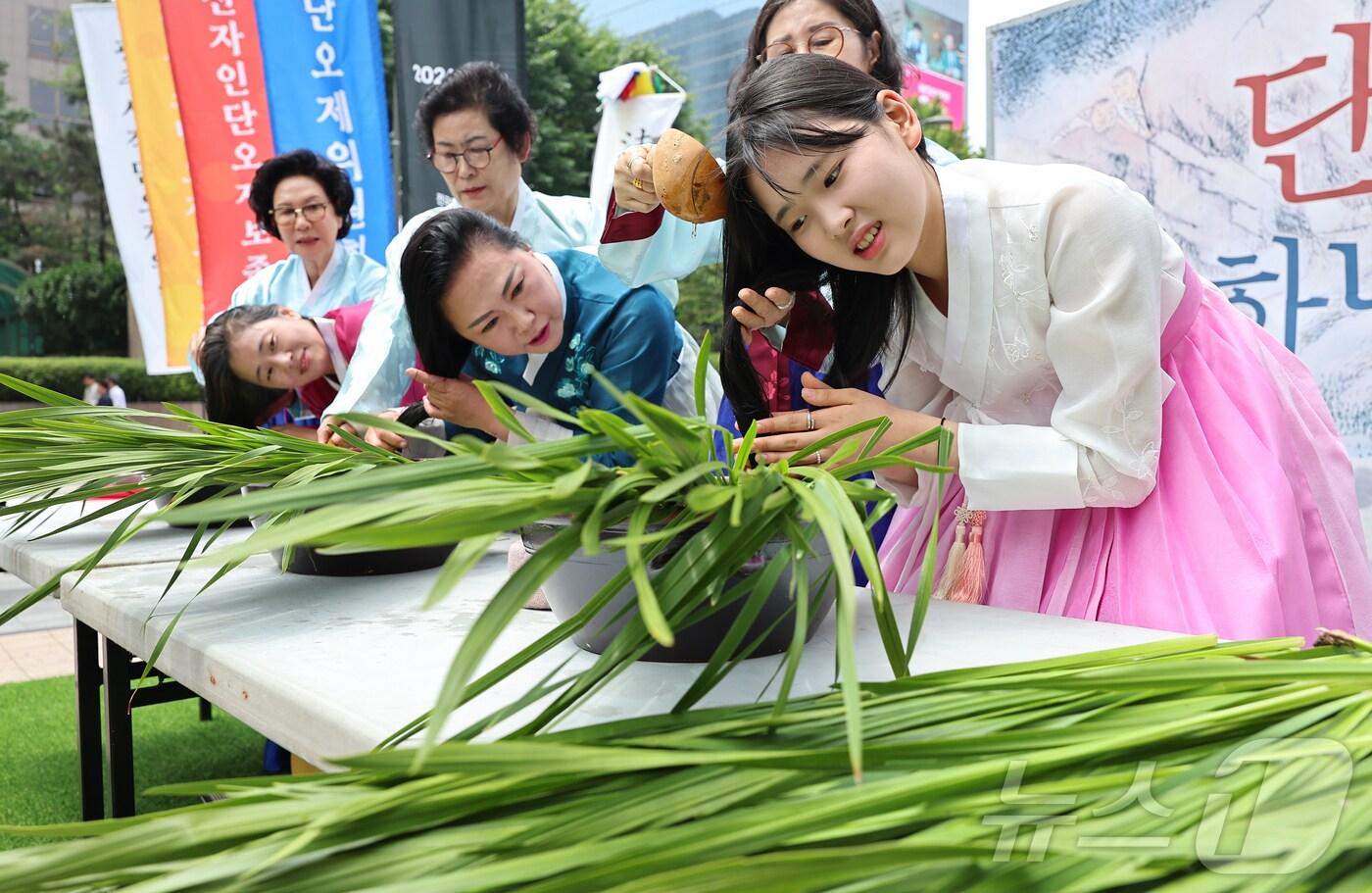 22일 서울 중구 청계광장에서 열린 전국단오제연합 주최 &#39;단오, 단 하나가 되다&#39;에서 참가자들이 창포물에 머리감기를 하고 있다. &#39;단오, 단 하나가 되다&#39;는 단오제 관련 단체들이 모여 단오제의 전통과 문화를 널리 알리고 지역 간 교류와 협력을 강화하기 위해 마련됐다. 2024.5.22/뉴스1 ⓒ News1 김도우 기자