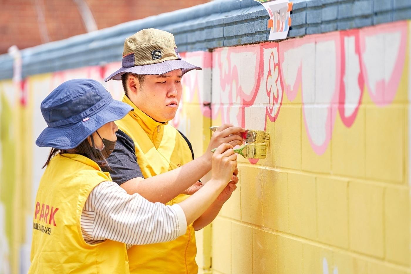 HDC현대산업개발은 지난 24일 HDC그룹사 연합봉사에 참여해 용산구 관내 삼광초 어린이와 인근 주민들의 거주환경 개선을 위한 벽화 그리기 봉사활동을 진행했다&#40;HDC현산 제공&#41;.
