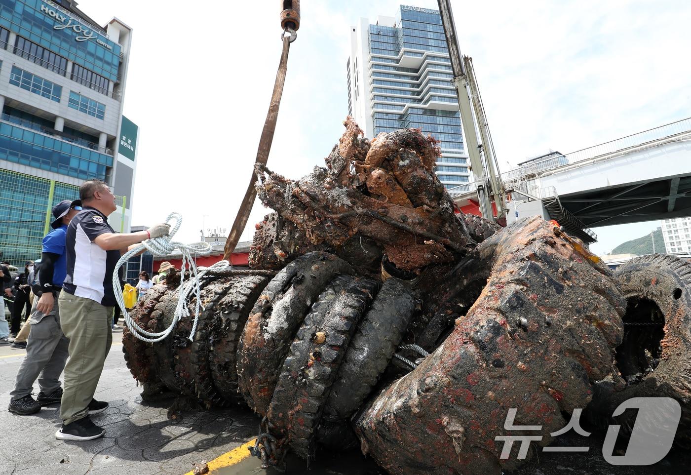 제29회 바다의 날을 사흘 앞둔 28일 부산 영도구 봉래동 물양장에서 중앙해양특수구조단, 한국해양구조협회 전문 다이버 등이 바닷속에 버러져 있던 폐타이어를 크레인을 동원해 육지로 끌어올리고 있다. 2024.5.28/뉴스1 ⓒ News1 윤일지 기자