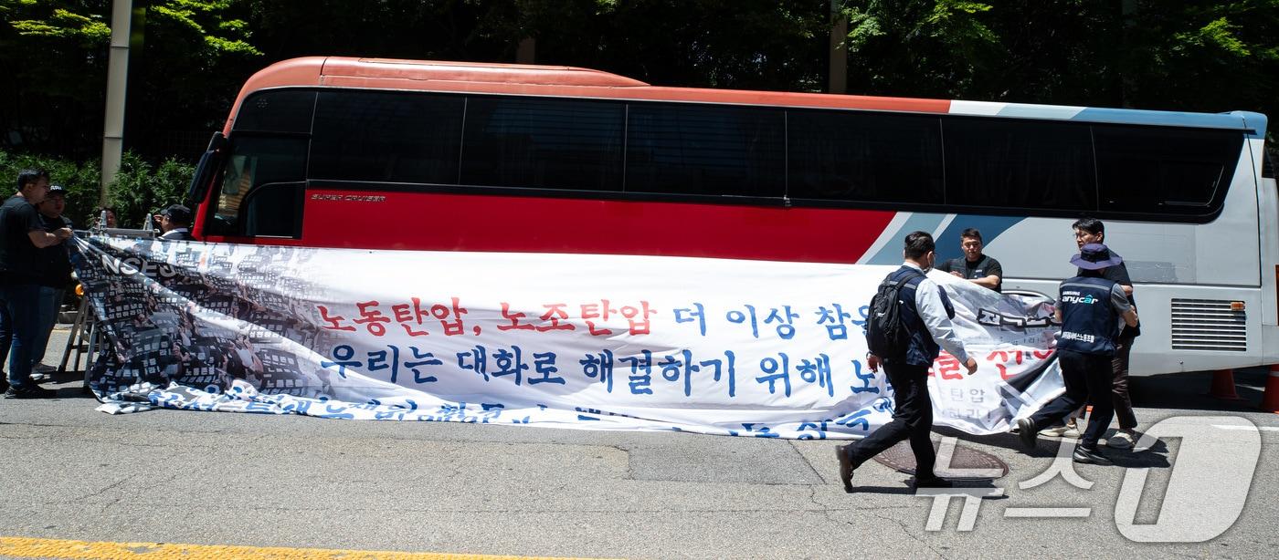 전국삼성전자노동조합 조합원들이 29일 서울 강남구 삼성전자 서초사옥 앞에서 파업 선언 기자회견을 마친 후 대형버스에 현수막을 매다는 퍼포먼스를 하고 있다. 삼성전자 최대 노조인 전국삼성전자노조는 삼성전자 창사 이후 첫 파업을 선언하며 &#34;사측이 교섭 조건을 받아들이지 않아 즉각 파업에 임한다＂며 ＂모든 책임은 노조를 무시하는 사측에 있다＂고 주장했다. 2024.5.29/뉴스1 ⓒ News1 유승관 기자