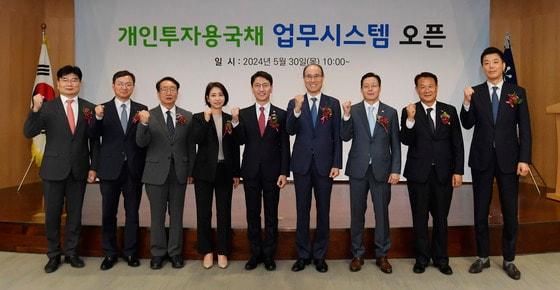 30일 오전 서울 영등포구 한국예탁결제원에서 열린 &#39;개인투자용 국채 업무시스템 오픈 행사&#39;에서 김윤상 기획재정부 차관&#40;왼쪽 다섯 번째&#41; 등 참석자들이 파이팅을 외치고 있다. 내달부터 발행하는 개인투자용 국채는 판매대행기관인 미래에셋증권의 영업점을 방문하거나 동 대행기관 웹사이트 또는 모바일앱을 통해 전용계좌를 개설한 후 구입할 수 있다. 1인당 최소 10만 원부터 연간 1억 원까지 구매 가능하다.&#40;기획재정부 제공&#41;