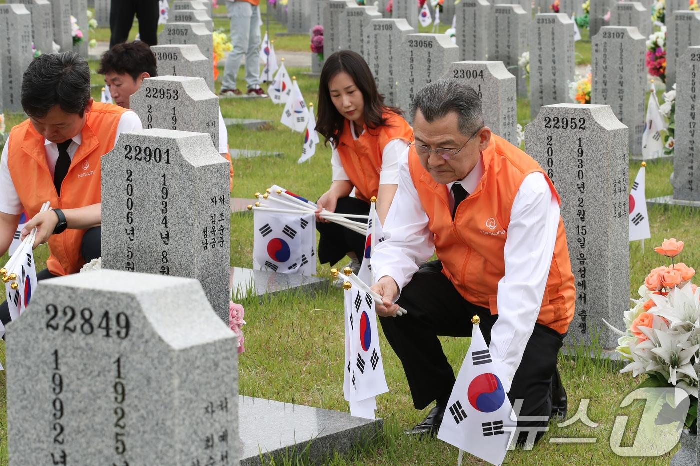 한화그룹 충청지역 봉사단이 6월 호국보훈의 달을 앞두고 30일 대전 유성구 국립대전현충원 장병3묘역에서 태극기 교체 등 봉사 활동을 하고 있다. 이날 봉사에는 김신연 한화사회봉사단장&#40;한화솔루션 사장&#41;을 비롯한 한화그룹 충청지역 사업장 대표자와 임직원 70여명이 참여했다. 2024.5.30/뉴스1 ⓒ News1 김기태 기자