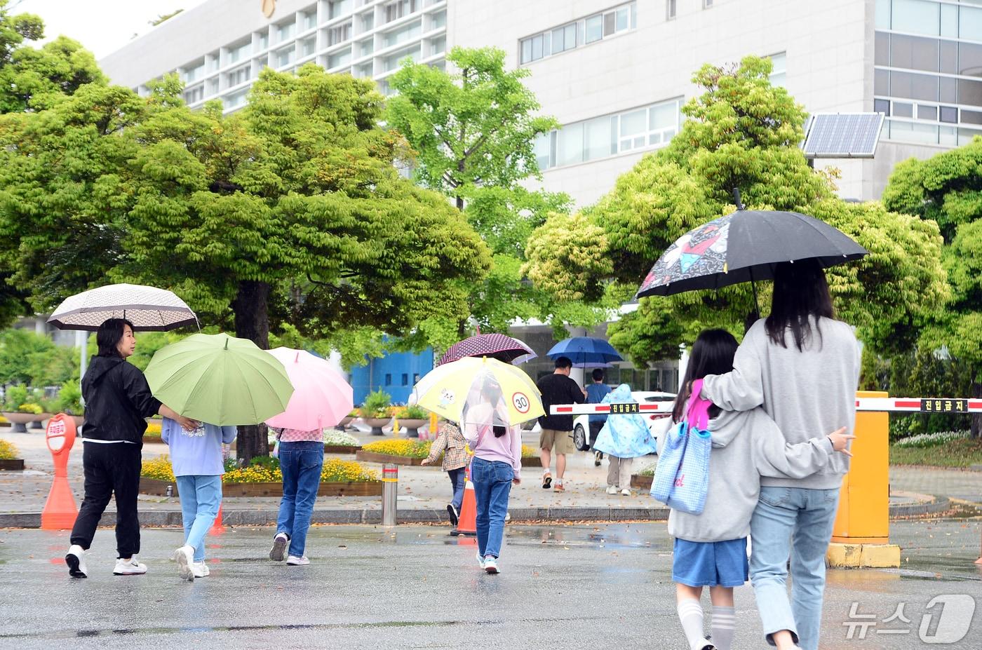 어린이날인 5일 오전 광주 서구 치평동 광주시청 청사 내부에서 열리는 행사에 참석하기 위해 가족들이 우산을 쓰고 이동하고 있다. 기존 행사는 잔디광장에서 열리기로 했지만 기상상황으로 인해 내부로 변경됐다. 2024.5.5/뉴스1 ⓒ News1 이승현 기자