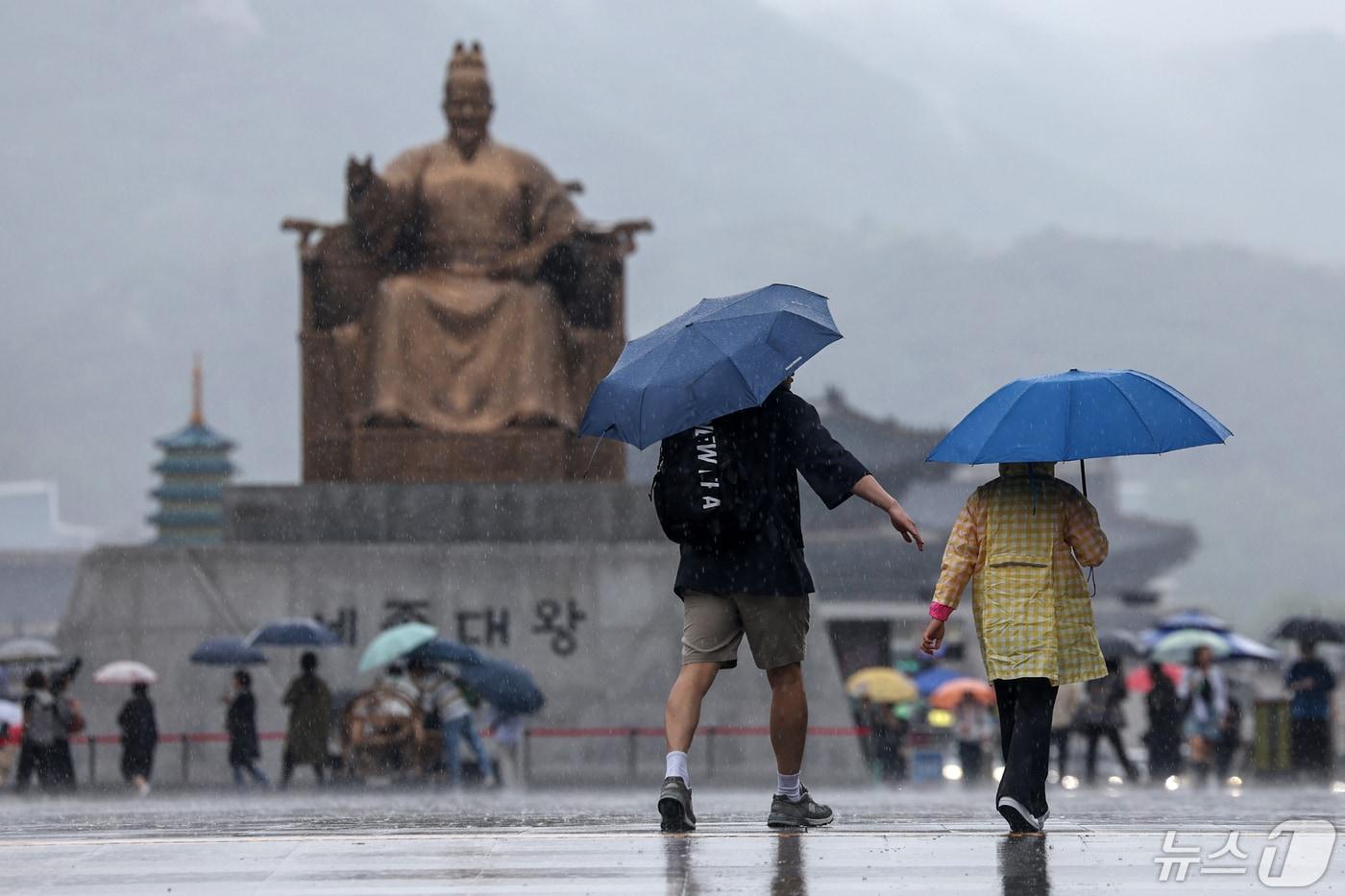 5일 서울 종로구 광화문광장에서 우산을 쓴 가족 나들이객이 쏟아지는 빗속에 걸음을 옮기고 있다2024.5.5/뉴스1 ⓒ News1 민경석 기자