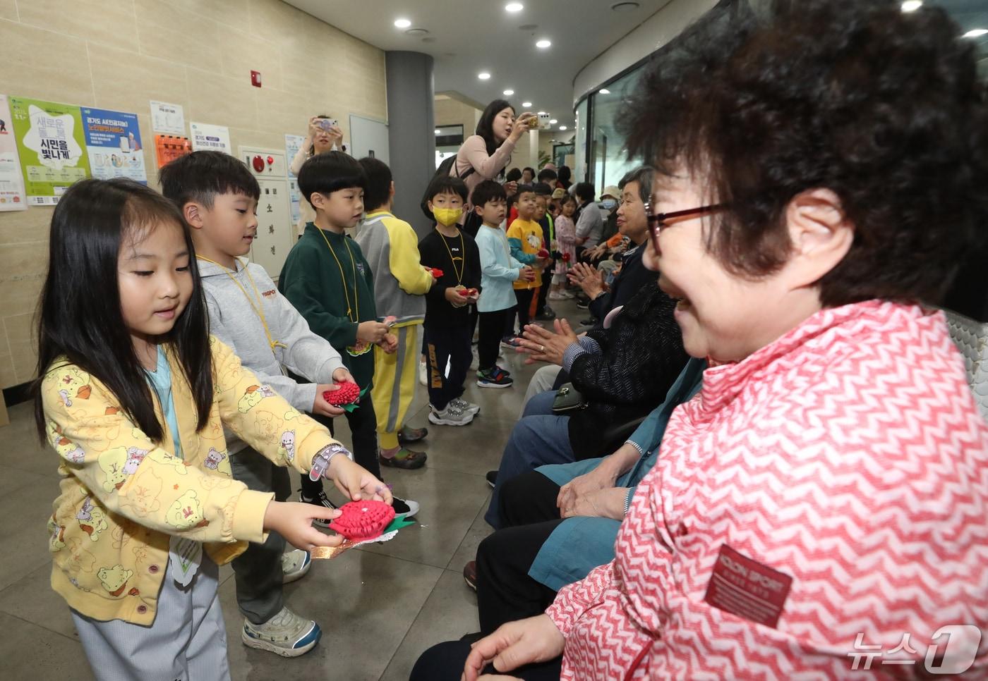 7일 경기 수원시 팔달구 팔달노인복지관에서 관내 어린이집 아이들이 어르신들에게 카네이션을 달아주고 있다. ⓒ News1 김영운 기자