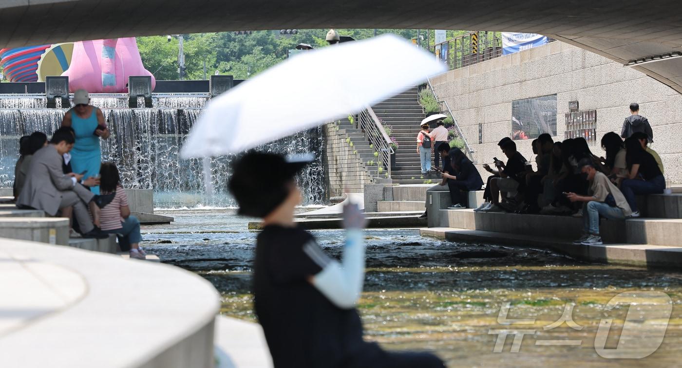 전국 대부분 지역의 낮 최고 기온이 30도에 이르며 더위가 이어진 10일 서울 청계천을 찾은 시민들이 그늘 밑에서 휴식을 취하고 있다. 2024.6.10/뉴스1 ⓒ News1 김도우 기자