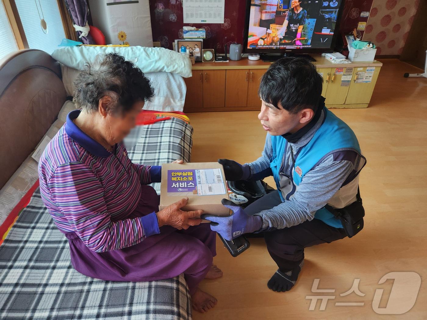 홍성군의 한 집배원이 노인가정을 방문해 생활용품이 들어 있는 ‘안부살핌 복지소포’ 을 전달하고 있다. &#40;홍성군 제공&#41; /뉴스1