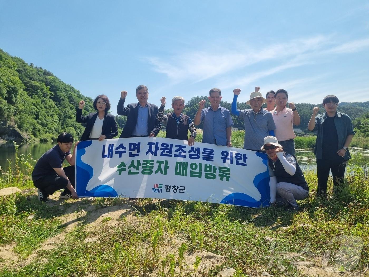 강원 평창군이 12일 평창강 일원에 뱀장어 수산종자 9000마리를 방류한 가운데, 이날 방류 행사의 참석자들이 기념사진을 촬영하고 있다. &#40;평창군 제공&#41; 2024.6.12/뉴스1