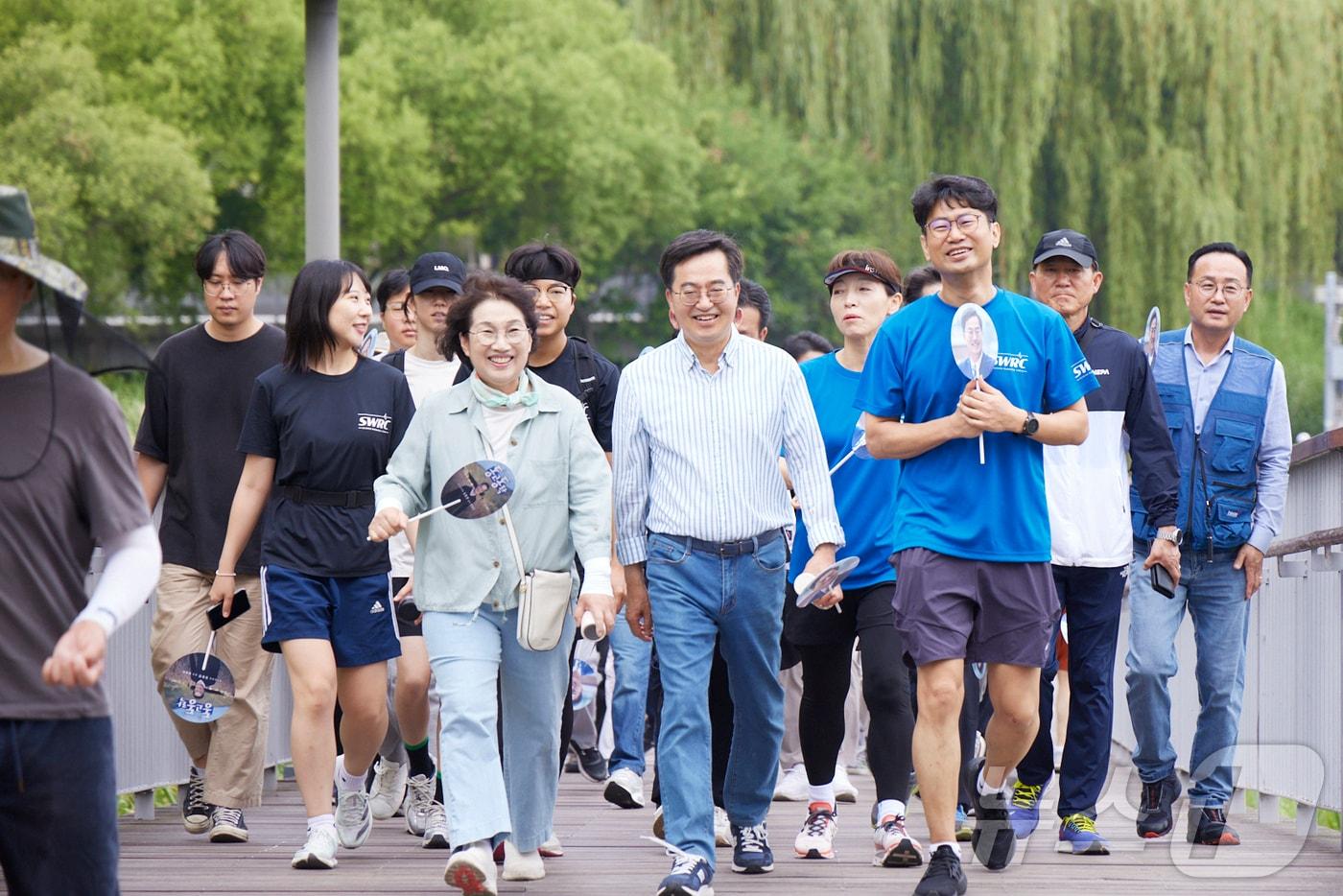 김동연 경기도지사가 도민들과 함께 수원시 광교 호수공원을 걸으며 대화를 나누고 있다.